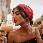 attractive-brunette-haired-girl-with-pink-headband-round-silver-earrings-bright-bandana-black-shirt-drinking-cocktail (1)